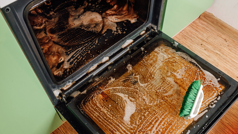 Open oven covered in foamy oven cleaner