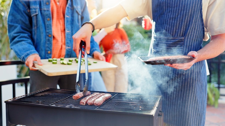 Backyard barbecue with person using grill