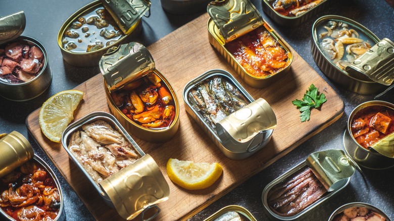 Overview of a charcuterie spread of many different tinned fish cans