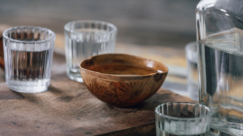 Glasses and bowl of clear spirit