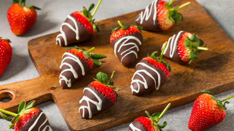 Chocolate-covered strawberries on a wooden board