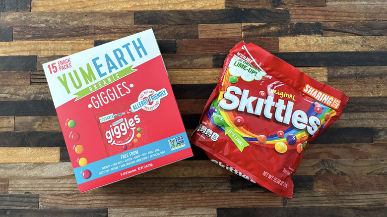 YumEarth Giggles and Skittles in packages on wooden table